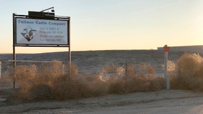 This Dec. 11, 2017 photo, shows a sign outside the Fullmer Cattle Co. in Syracuse, Kan. Several former workers say the western Kansas calf ranch forces immigrants to toil long days to work off loans from Fullmer Cattle Co. for the cost of smuggling them into the country. There are no holidays off, health insurance benefits, or overtime pay.