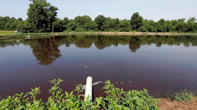 In this July 21, 2017 file photo, a hog waste pond is seen at a farm that has hogs owned by Smithfield Foods in Farmville, N.C. A federal jury decided Friday, Aug. 3, 2018, that the world's largest pork producer should pay $473.5 million to neighbors of three North Carolina industrial-scale hog farms for unreasonable nuisances they suffered from odors, flies and rumbling trucks. The jury found that Smithfield Foods owes compensation to 16 neighbors who complained in their lawsuit that the company failed to stop “the obnoxious, recurrent odors and other causes of nuisance” resulting from closely packed hogs, which “generate many times more sewage than entire towns.”