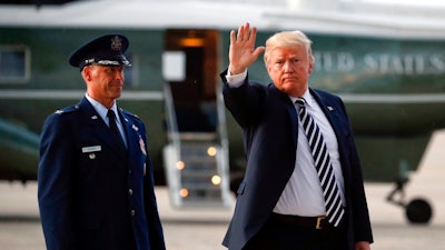 President Donald Trump waves to members of the media after arriving on Air Force One, Friday, Aug. 31, 2018 at Andrews Air Force Base in Md. Watching is Air Force Col. Samuel Chesnut.