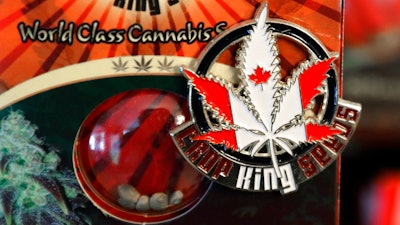 In this Sept. 24, 2018 photo, a pin promoting Crop King Seeds, with the colors and maple-leaf logo of the Canadian flag, is displayed on a package of marijuana seeds for sale at the Warmland Centre, a medical marijuana dispensary in Mill Bay, British Columbia, on Vancouver Island in Canada. On Oct. 17, 2018, Canada will become the second and largest country with a legal national marijuana marketplace.