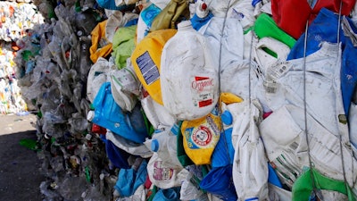 In this Thursday, Sept. 6, 2018, photo, bundled plastic goods, which were separated from paper and metal recyclable materials, are stacked and awaiting processing at EL Harvey & Sons, a waste and recycling company, in Westborough, Mass. Recycling programs across the United States are shutting down or scaling back because of a global market crisis blamed on contamination at the curbside bin.