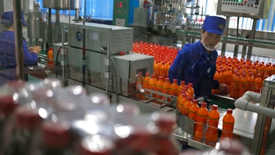 In this Oct. 22, 2018, photo, a worker monitors the production of bottled beverage at Songdowon General Foodstuffs Factory in Wonsan, North Korea. Though the international spotlight has been on his denuclearization talks with Washington, the North Korean leader has a lot riding domestically on his promises to boost the country's economy and standard of living. His announcement in April that North Korea had sufficiently developed its nuclear weapons and would now focus on building its economy marked a sharp turn in official policy and set the stage for his rapid-fire meetings with the leaders of China, South Korea and the United States.