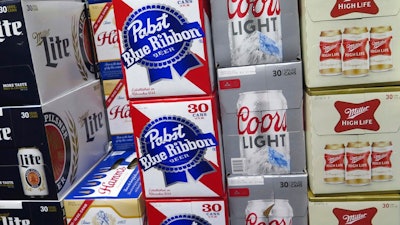 In this photo taken on Thursday, Nov. 8, 2018, cases of Pabst Blue Ribbon and Coors Light are stacked next to each other in a Milwaukee liquor store. Pabst Brewing Company and MillerCoors are heading to trial starting Monday, Nov. 12, to settle a contract dispute in which Pabst accuses the brewing giant of trying to undermine its competitor by breaking a contract to make their products.