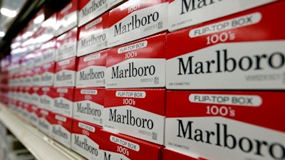 his June 14, 2018, file photo shows cartons of Marlboro cigarettes on the shelves at JR outlet in Burlington, N.C. Curiosity from one the world's largest tobacco companies about the marijuana business sent shares of a Canadian cannabis company higher at the opening bell Tuesday, Dec. 4. Cronos Group confirmed talks late Monday with Marlboro maker Altria about a possible investment.