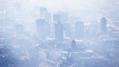 In this Jan. 18, 2017, file photo, smog covers Salt Lake City as an inversion lingers. When it comes to their views on climate change, Americans are looking at natural disasters and their local weather, according to a new poll.