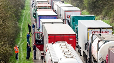 In this April 6, 2016 file photo, truck drivers stand among trucks on the highway from Brussels to Luxembourg, in Spontin, Belgium. The European Union has reached a tentative agreement on the first specific EU standards for trucks to get polluting CO2 levels down. A Tuesday, Feb. 19, 2019, agreement between negotiators from the European Parliament and member states says that such emissions will have to be 30 percent down by 2030 compared to today's levels.