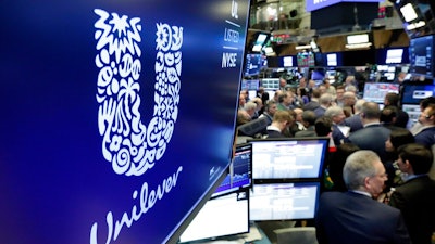 In this Thursday, March 15, 2018 file photo, the logo for Unilever appears above a trading post on the floor of the New York Stock Exchange. A report published Monday by the non-governmental group CDP found consumer goods giants are working to lower their carbon emissions, prepare for the effects of global warming and respond to growing environmental consciousness among customers.
