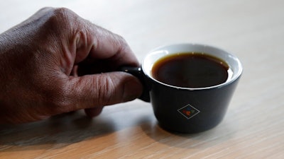Klatch Coffee owner Bo Thiara holds a cup of Elida Natural Geisha coffee at his shop in San Francisco, Wednesday, May 15, 2019. The California cafe is brewing up what it calls the world's most expensive coffee - at $75 a cup. Klatch Coffee Roasters is serving the exclusive brew, the Elida Natural Geisha 803, at its branches in Southern California and San Francisco.