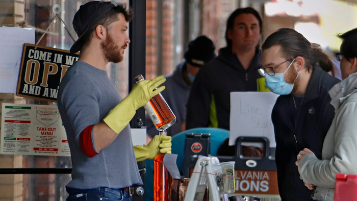 In this April 16 photo, people line up to purchase Pennsylvania made liquor at Pennsylvania Libations in Pittsburgh's Strip District. The Pennsylvania liquor control board closed the Pennsylvania state-owned stores that retail nearly all of Pennsylvania's liquor in March, driving up demand from the state's distilleries, which have been allowed to continue production and sales, although some report stockpiles are rapidly drying up.