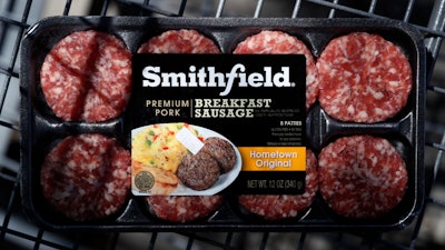 In this April 14 photo, a package of Smithfield Foods breakfast sausage sits in a shopping cart outside of a local grocery story, in Des Moines, IA.