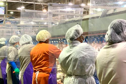 Tyson Foods workers wear protective masks and stand between plastic dividers at the company's Camilla, Georgia poultry processing plant.