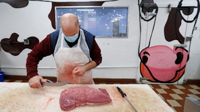 John Warminski prepares meat at Ronnie's Quality Meats in Detroit on Wednesday, April 29. President Donald Trump has ordered meat processing plants to stay open amid concerns over growing coronavirus COVID-19 cases and the impact on the nation's food supply.