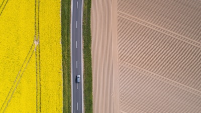 A lorry drives along a country road that between a flowering rape field and a freshly tilled field in Pattensen, Germany on April 28.
