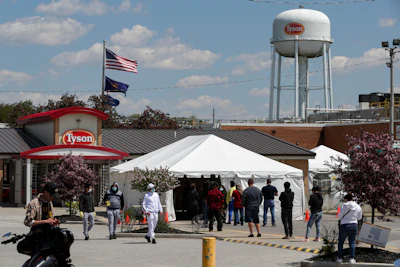 Workers line up to enter the Tyson Foods pork processing plant in Logansport, IN on May 7.