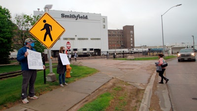 Residents cheered and held thank you signs to greet employees of a Smithfield pork processing plant as they begin their shift on Wednesday, May 20 in Sioux Falls, SD.