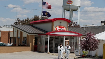 In this May 7 photo, workers leave the Tyson Foods pork processing plant in Logansport, IN.
