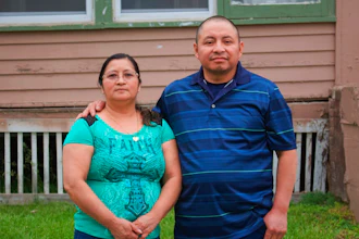 In this photo provided by Cristobal Francisquez, his parents Paulina and Marcos Francisco pose for a photo in front of their house in Sioux City, Iowa, Monday, May 25, 2020. They bought the home after years of working in a meatpacking plant and other food processing jobs.