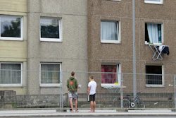 Two people stand at a fence separate a quarantined apartment building in Goettingen, Germany on Monday, June 22. The city council has quarantined an entire residential complex to contain the coronavirus in the area.
