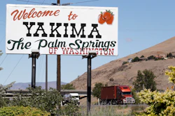 In this photo taken June 17, a sign declares off the highway in Yakima, Wash., declares the city the 'Palm Springs of Washington.' The coronavirus pandemic is hitting Yakima County hard, with cases surging far faster in than in the rest of the state. The virus has caused turmoil in the farm and food processing industries, where some fearful workers staged wildcat strikes recently to demand that employers provide safer working conditions.
