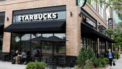 In this July 10, 2019 photo, customers visit at a Starbucks in Minneapolis. Starbucks is adding plant-based meat to its U.S. menu for the first time.