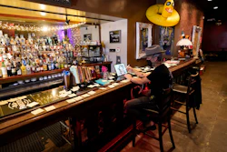Michael Neff, co-owner of the Cottonmouth Club, works on a computer while sitting at the bar on June 23 in Houston. Neff closed his downtown bar because of concerns within the industry as the number COVID-19 case continues to rise in Houston.