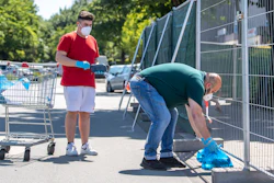 Employees of a grocery store deliver ordered products in plastic bags to residents of apartment buildings that are partly under quarntine due to a new coronavirus outbreak in Verl, Germany on Wednesday, June 24.
