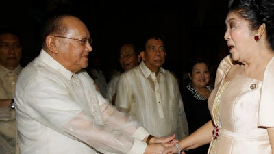 In this June 19, 2011, file photo, San Miguel Corporation chairman Eduardo Cojuangco Jr., left, greets then congresswoman Imelda Marcos, the widow of the late strongman Ferdinand Marcos, during the 40th wedding anniversary of Philippine Senator Miriam Santiago and Narciso at Manila's Cathedral in Philippines. Philippine tycoon Cojuangco, a key ally of the late dictator Ferdinand Marcos and a low-key businessman who led a food and beverage empire that produced San Miguel beer, has died Tuesday night, June 16, 2020. He was 85.
