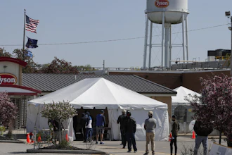 Workers wait in line to enter the Tyson Foods pork processing plant in Logansport, IN on May 7.
