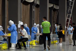Workers in protective suits administer coronavirus tests at a COVID-19 testing site for those who were potentially exposed to the coronavirus at a wholesale food market in Beijing on Wednesday, June 17. As the number of cases of COVID-19 in Beijing climbed in recent days following an outbreak linked to a wholesale food market, officials announced they had identified hundreds of thousands of people who needed to be tested for the coronavirus.