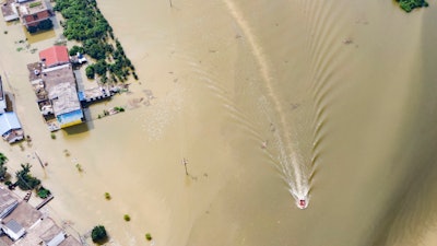 In this aerial photo released by Xinhua News Agency, rescue workers on a raft are seen moving through flood waters to help evacuate trapped residents in Sanjiao Township of Yongxiu County in central eastern China's Jiangxi Province on Monday, July 13.