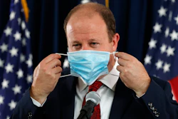 Colorado Governor Jared Polis puts on his face mask after concluding a news conference on the state's efforts against the new coronavirus on Tuesday, July 21 in Denver.