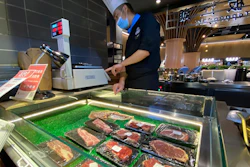 A worker weighs beef products on sale at a food court in Beijing on Friday, Aug. 28.