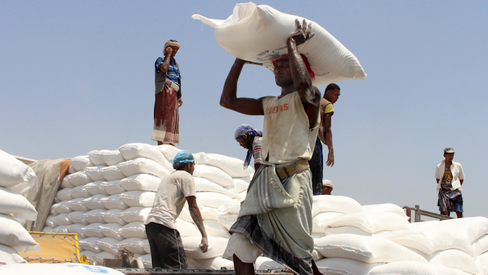 In this Sept. 21, 2018 file photo, men deliver U.N. World Food Programme aid in Aslam, Hajjah, Yemen.