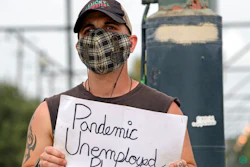 Sean Harris holds a sign asking for help.