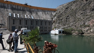 Farmers stand at La Boquilla Dam, where they wrested control on Tuesday from National Guard troops in order to close the valves and reduce the flow of water toward the United States, in Chihuahua State, Wednesday, Sept. 9.