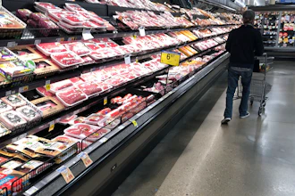 In this May 10, 2020 photo, a shopper pushes his cart past a display of packaged meat in a grocery store in southeast Denver.