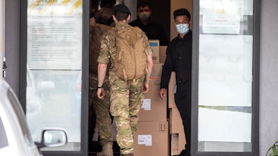 Military personnel enter the Sudima Hotel in Christchurch, New Zealand on Tuesday, Oct. 20.