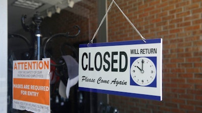 In this July 18, 2020 file photo a closed sign hangs in the window of a barber shop in Burbank, Calif. A critical snapshot of the job market and the economy to be released Friday, Oct. 2, is expected to show a further deceleration in hiring as the nation’s viral caseload creeps higher just as financial aid from the government has faded.
