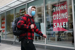 A passer-by walks past a store closing sign in Boston, Oct. 27, 2020.