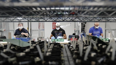 Line workers put together ventilators at the Ford Rawsonville plant in Ypsilanti Township, Mich., May 13, 2020.