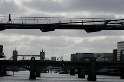 A pedestrian walks across the Millennium Bridge in London, May 11, 2020.