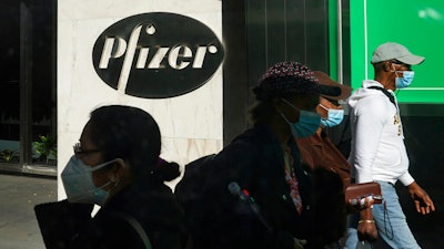 Pedestrians walk past Pfizer world headquarters in New York.