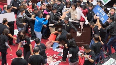 In this image made from video, lawmakers fight during a parliament session in Taipei, Taiwan on Friday, Nov. 27.