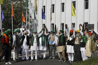 Representatives of various farmers organizations hold hands before the media as they arrive for talks with the government representatives in New Delhi, India on Thursday, Dec. 3.