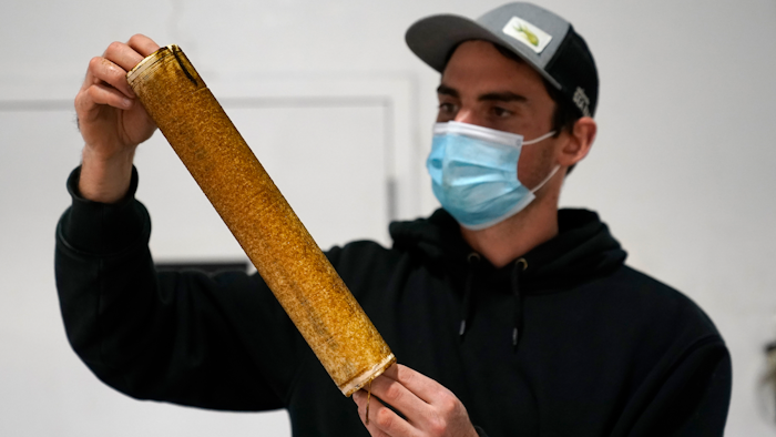 James Crimp, kelp supply director for Atlantic Sea Farms, inspects the growth of seaweed spores on a spool of twine at the company's nursery, Tuesday, Dec. 8, 2020, in Saco, Maine. The twine will be wrapped around line and set out to grow in the ocean until harvest time in the spring. (