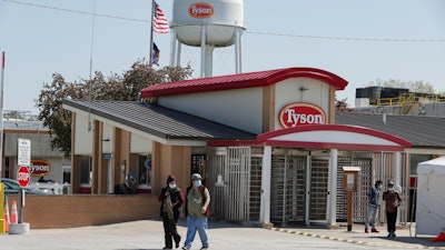 In this May 7 file photo, workers enter and leave the Tyson Foods pork processing plant in Logansport, IN.
