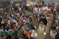 An elderly farmer shouts slogans as others listen to a speaker as they block a major highway during a protest to abolish new farming laws they say will result in exploitation by corporations, eventually rendering them landless, at the Delhi-Haryana state border, India on Dec. 1.