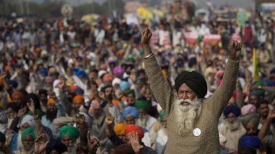 An elderly farmer shouts slogans as others listen to a speaker as they block a major highway during a protest to abolish new farming laws they say will result in exploitation by corporations, eventually rendering them landless, at the Delhi-Haryana state border, India on Dec. 1.