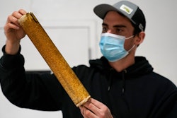 James Crimp, kelp supply director for Atlantic Sea Farms, inspects the growth of seaweed spores on a spool of twine at the company's nursery, Tuesday, Dec. 8, 2020, in Saco, Maine. The twine will be wrapped around line and set out to grow in the ocean until harvest time in the spring. (