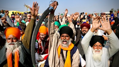 Protesting farmer leaders shout slogans as they sit on a day-long hunger strike at the Delhi- Haryana border on outskirts of New Delhi on Monday, Dec.14.